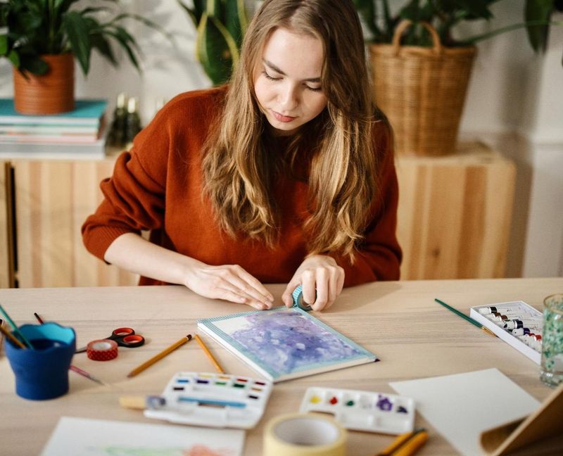 A woman painting with watercolours at a table